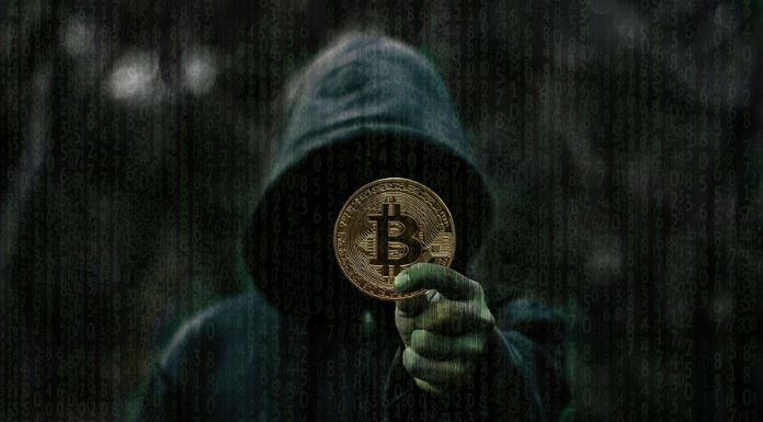 homem de capuz com moeda de bitcoin