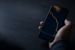 Gráfico de criptomoeda em queda no celular, armadilha de falsa exchange